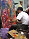 El profesor Ricardo Jimnez pinta junto a un alumno para el pblico asistente